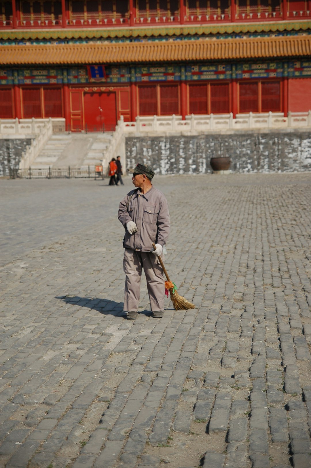 man-in-gray-coat-holding-brown-stick-walking-on-gray-concrete-pavement-during-daytime-1b74l2lcoty